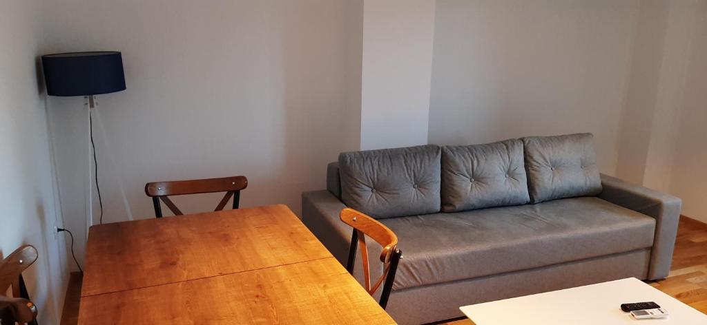 - un salon avec un canapé et une table en bois dans l'établissement Apartment Martin, à Gevgelija