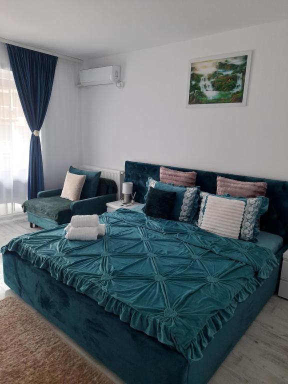 uma cama azul numa sala de estar com um sofá em Garsoniera Camy em Saturn