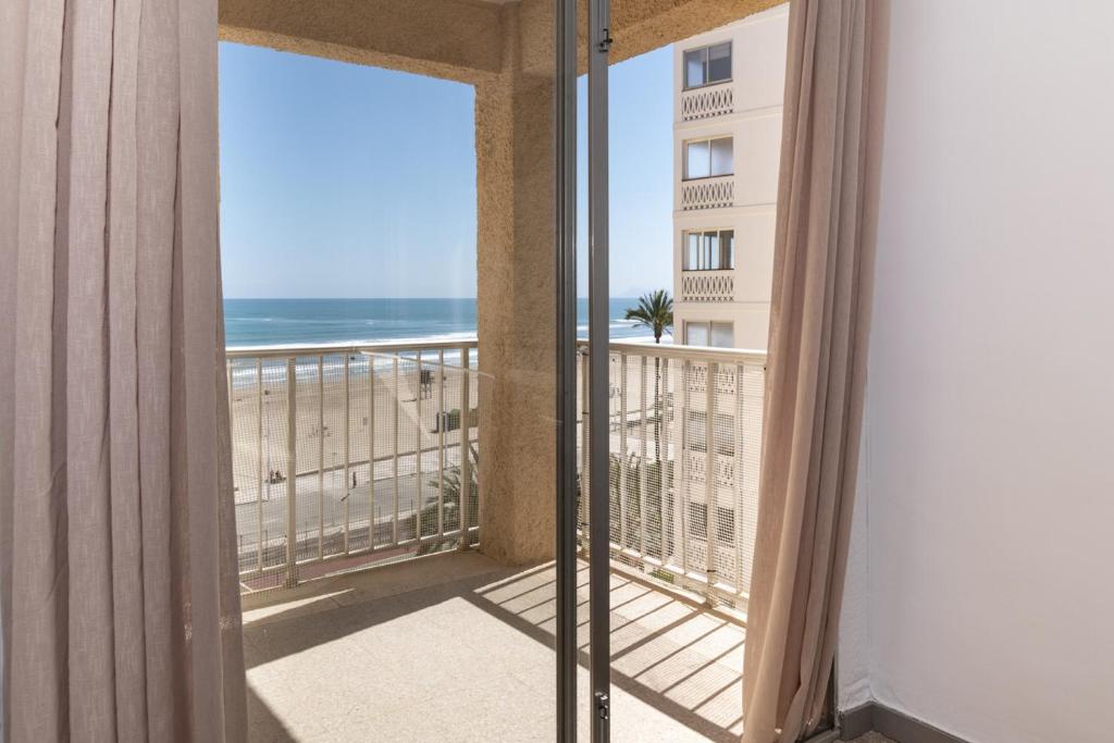 クリェラにあるEstrella, 6º-36のビーチの景色を望むバルコニー付きの客室です。