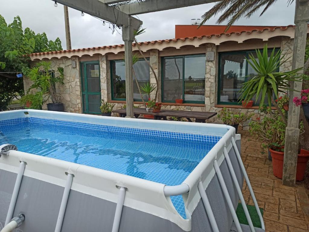 a swimming pool in front of a house at Caseta Morritos in Deltebre