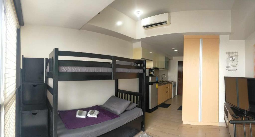 Pokój z łóżkiem piętrowym i telewizorem w obiekcie RENTZONE88 w mieście Manila