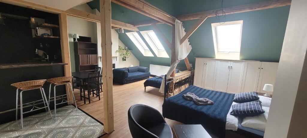 um pequeno quarto com uma cama e uma sala de estar em Orbis em Praga