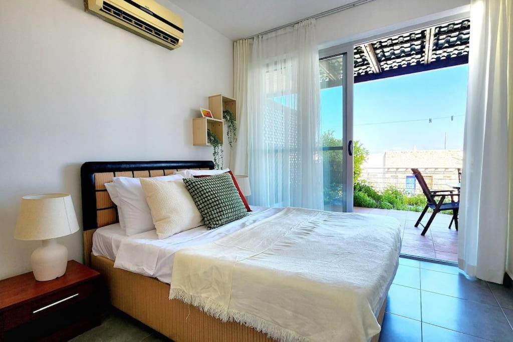a bedroom with a bed and a sliding glass door at 2 bedroom ground floor apartment in Kalogrea