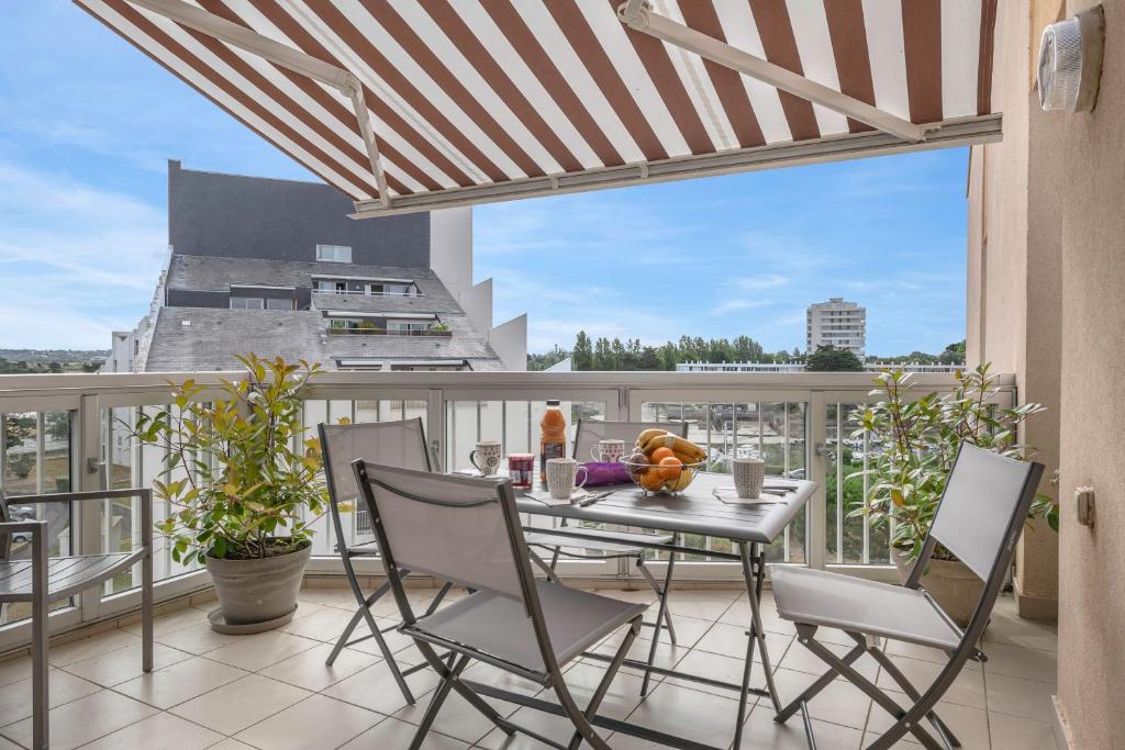 un patio avec une table et des chaises sur un balcon dans l'établissement Appartement pour 4 - 300m du centre-ville, au Pouliguen