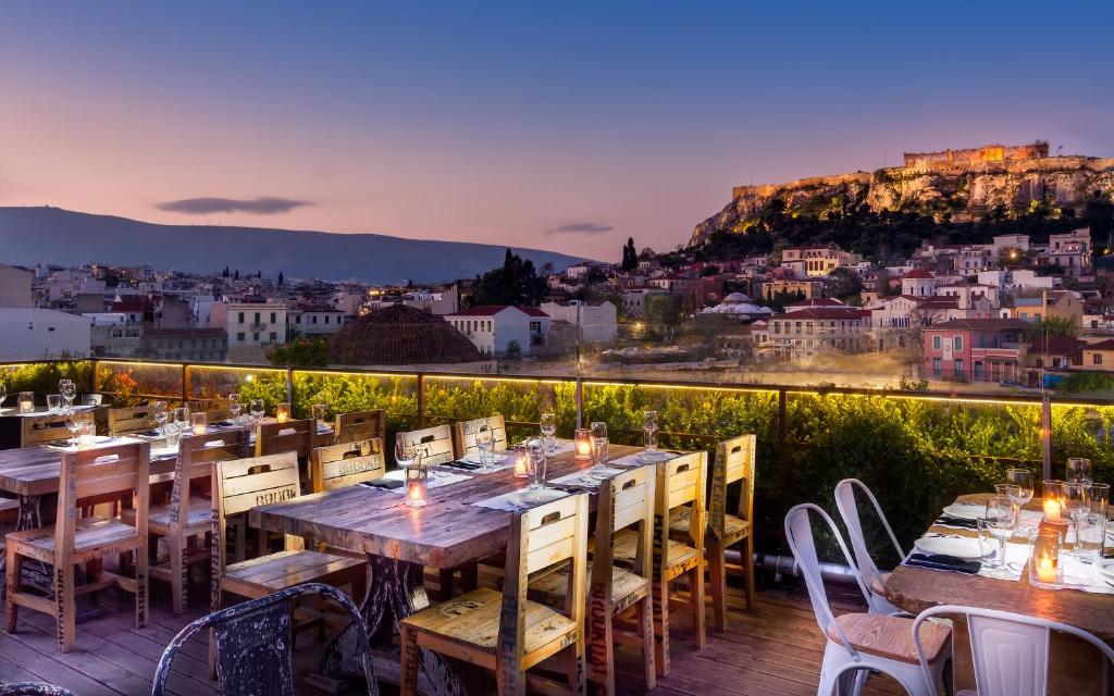 a restaurant with tables and chairs overlooking the ocean at 360 Degrees in Athens
