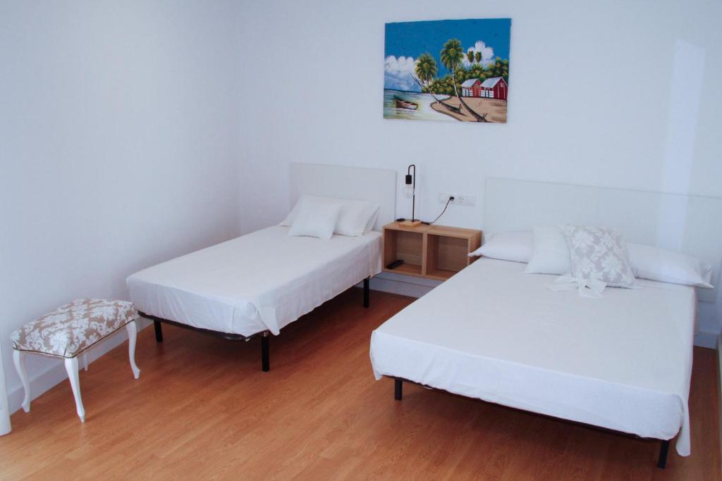 2 Betten und ein Stuhl in einem Zimmer in der Unterkunft Antich Apartment Deltebre in Deltebre
