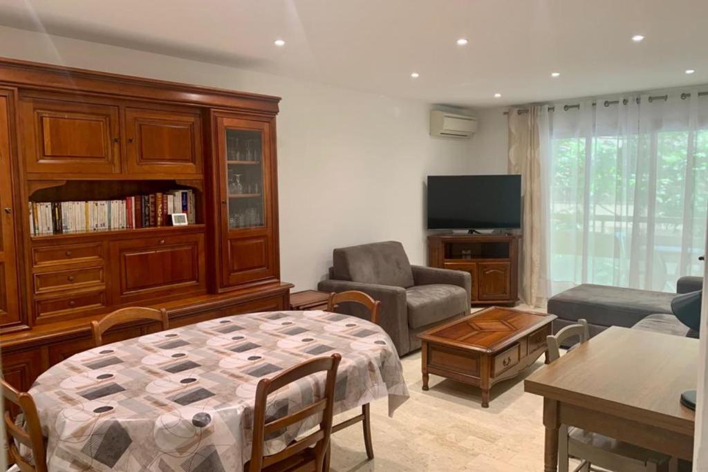 - un salon avec un lit, un canapé et une télévision dans l'établissement Le Roxane 2 bedroom apartment in the city-center of Antibes, à Antibes