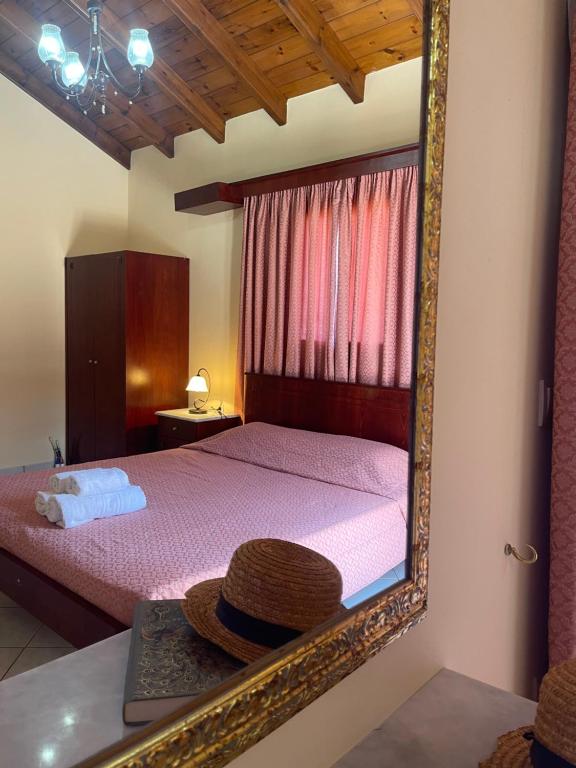 uno specchio che riflette un letto con un cappello su un tavolo di L'Eremo Luxury Apartments a Roda