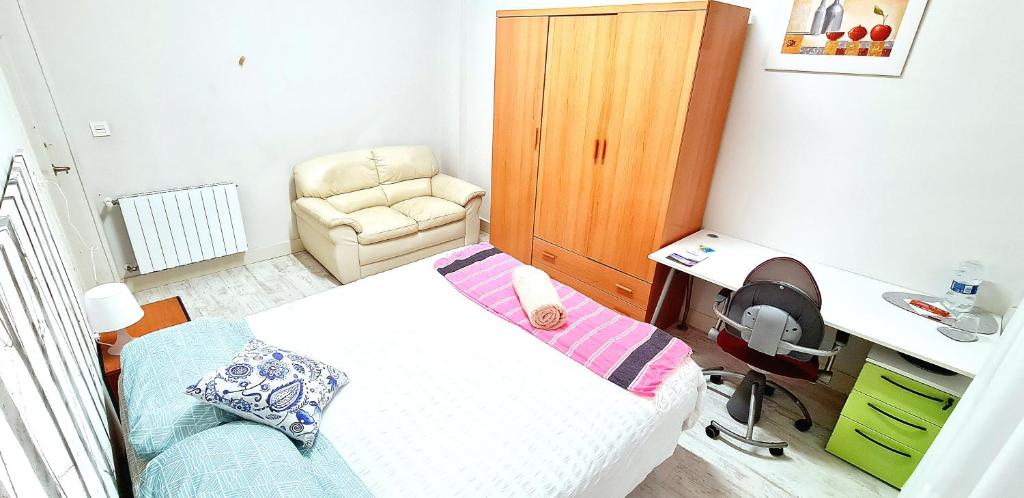 een kleine slaapkamer met een bed en een stoel bij Habitación privada en departamento familiar a pasos de la playa in San Sebastian
