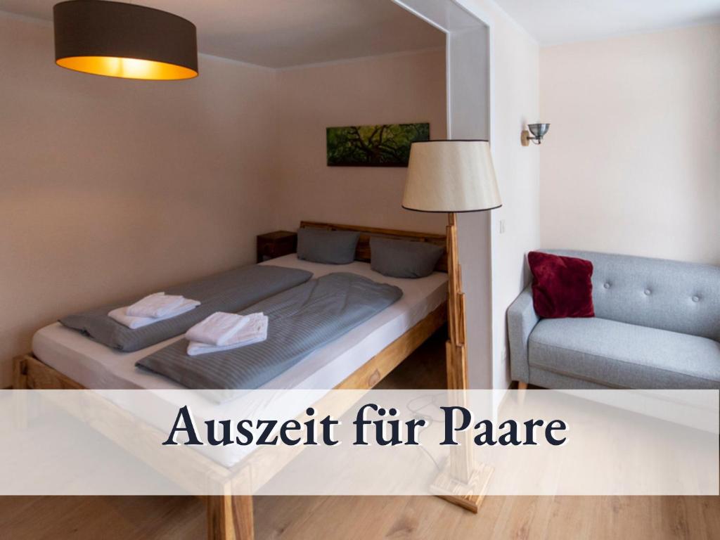 ein kleines Schlafzimmer mit einem Bett und einem Sofa in der Unterkunft Wohnung Achtermann in Braunlage