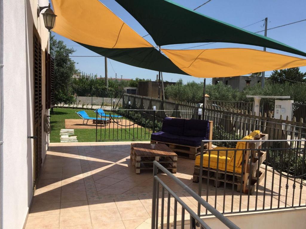 patio con sedie e ombrellone su un portico di Villa Cecilia a Sciacca