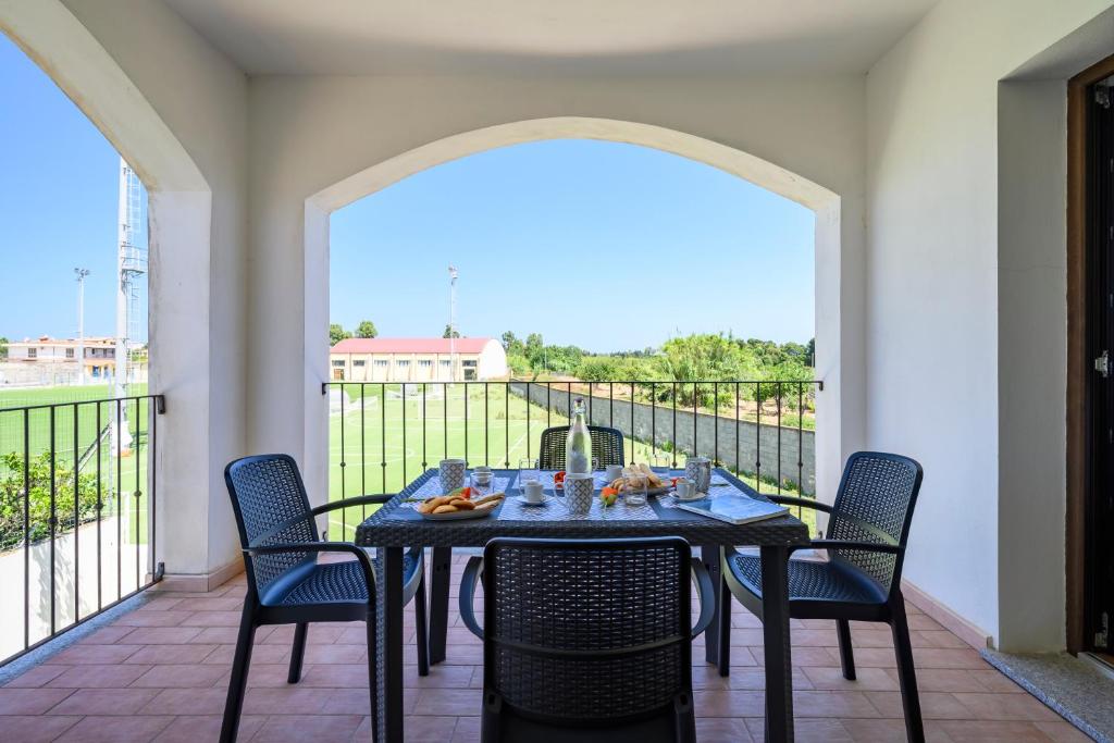 una mesa y sillas en un balcón con vistas en 6 - Meraviglioso appartamento con terrazza - Sa Crai Apartments Sardinian Experience en Lotzorai