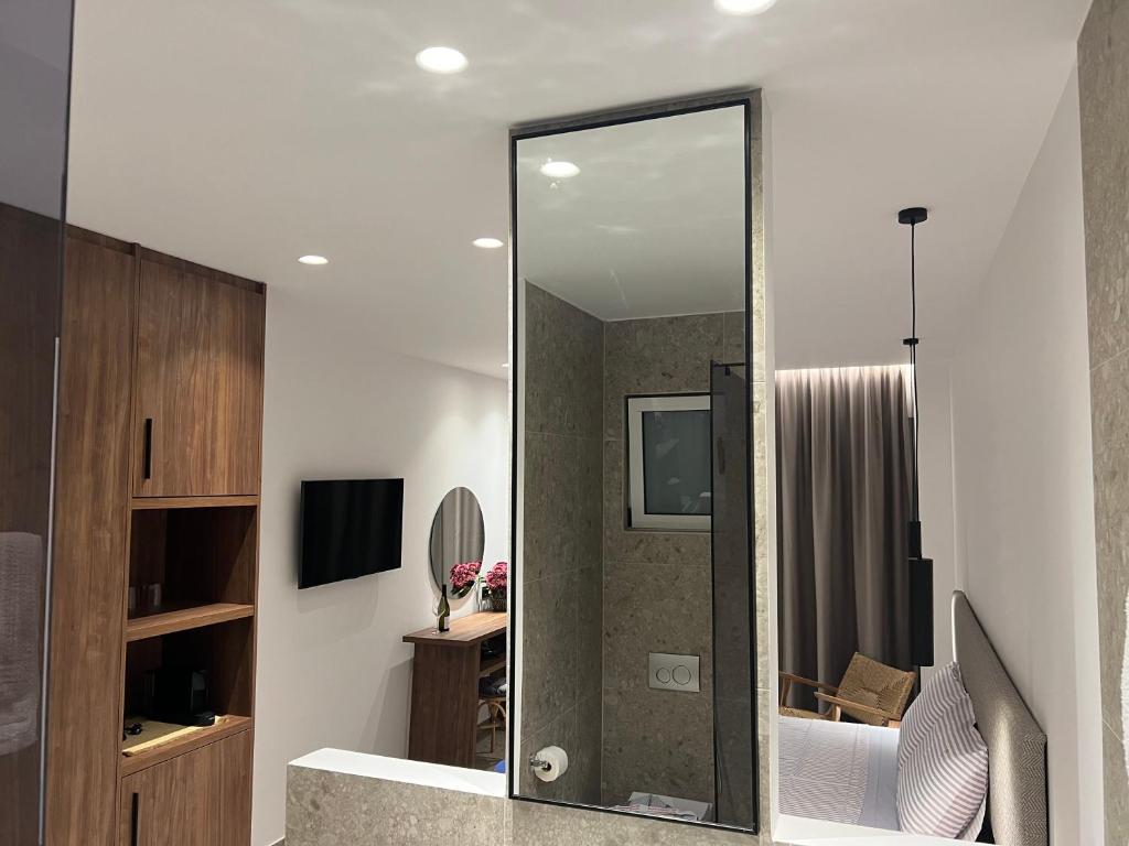 bagno con doccia e specchio di Johannes Boutique Apartments & Suites a Afantou