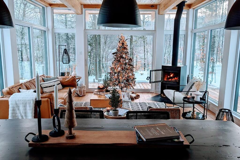 La Conceptionにあるträhus tremblantのクリスマスツリーと暖炉のあるリビングルーム