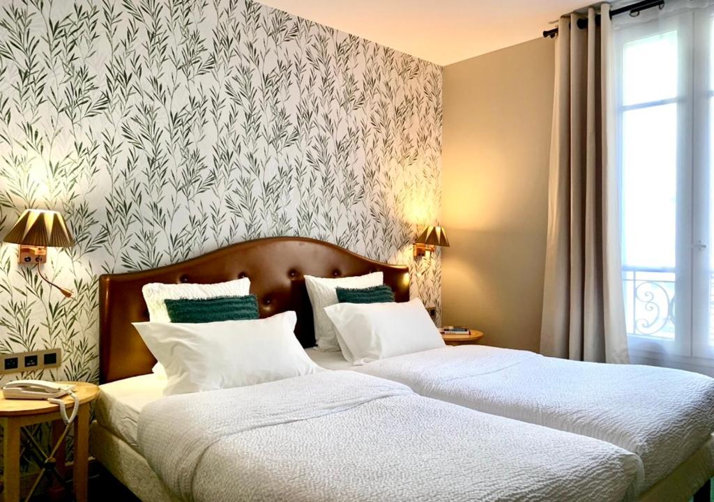 2 camas en un dormitorio con un mural en la pared en Hôtel Central Saint Germain, en París