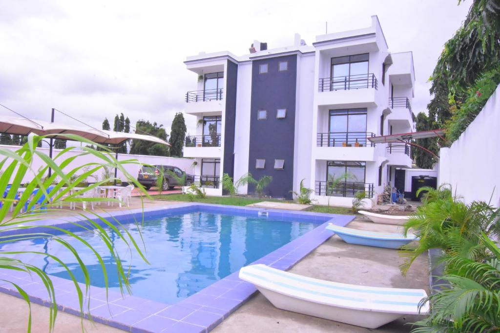 an apartment with a swimming pool in front of a building at Volume view Apartments in Mombasa