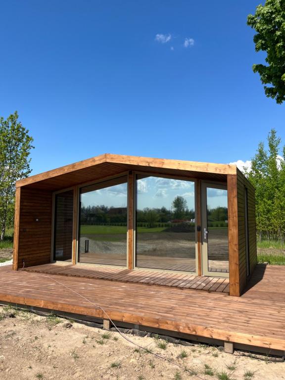 eine Hütte mit Glastüren auf einer Holzterrasse in der Unterkunft Looduskeskne Olivia moodulmaja Põltsamaal 