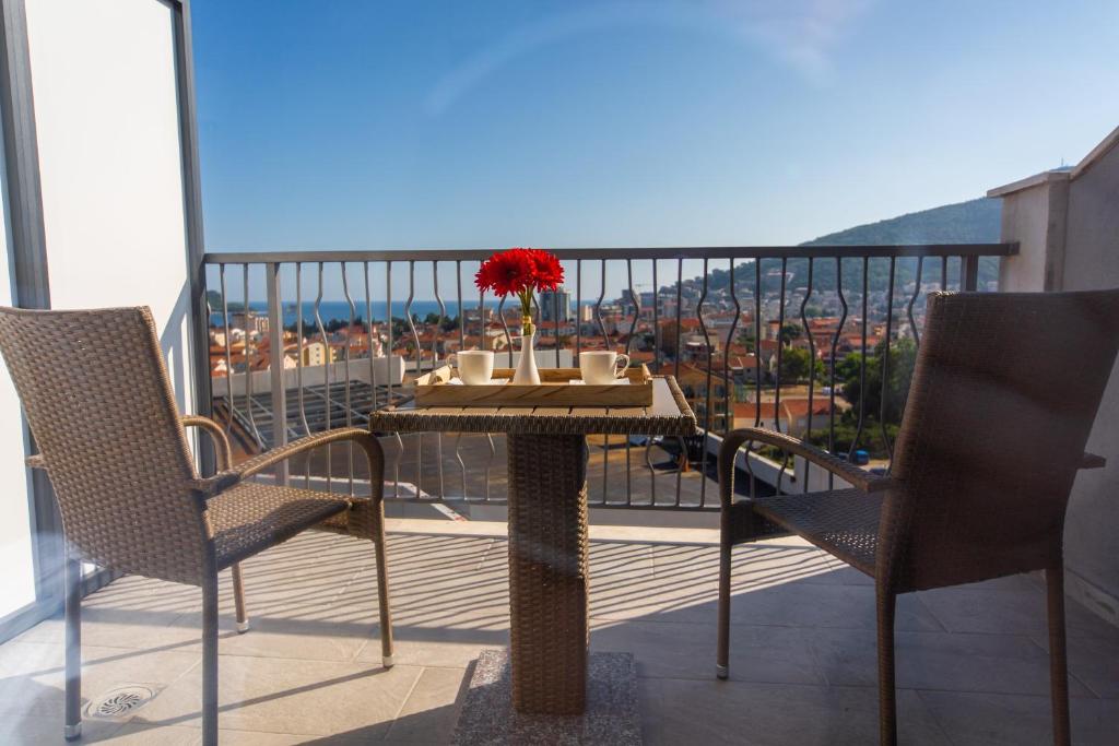 a table and chairs on a balcony with a view at Rooftop apartments & rooms Budva in Budva