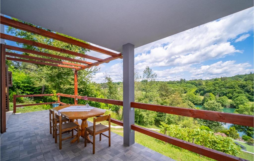 a porch with a table and chairs and a view at Lovely Home In Duga Resa With Outdoor Swimming Pool in Duga Resa