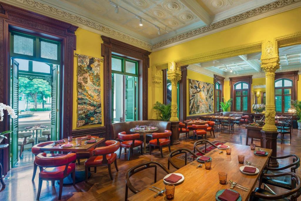 a restaurant with tables and chairs in a room at W Bangkok Hotel in Bangkok