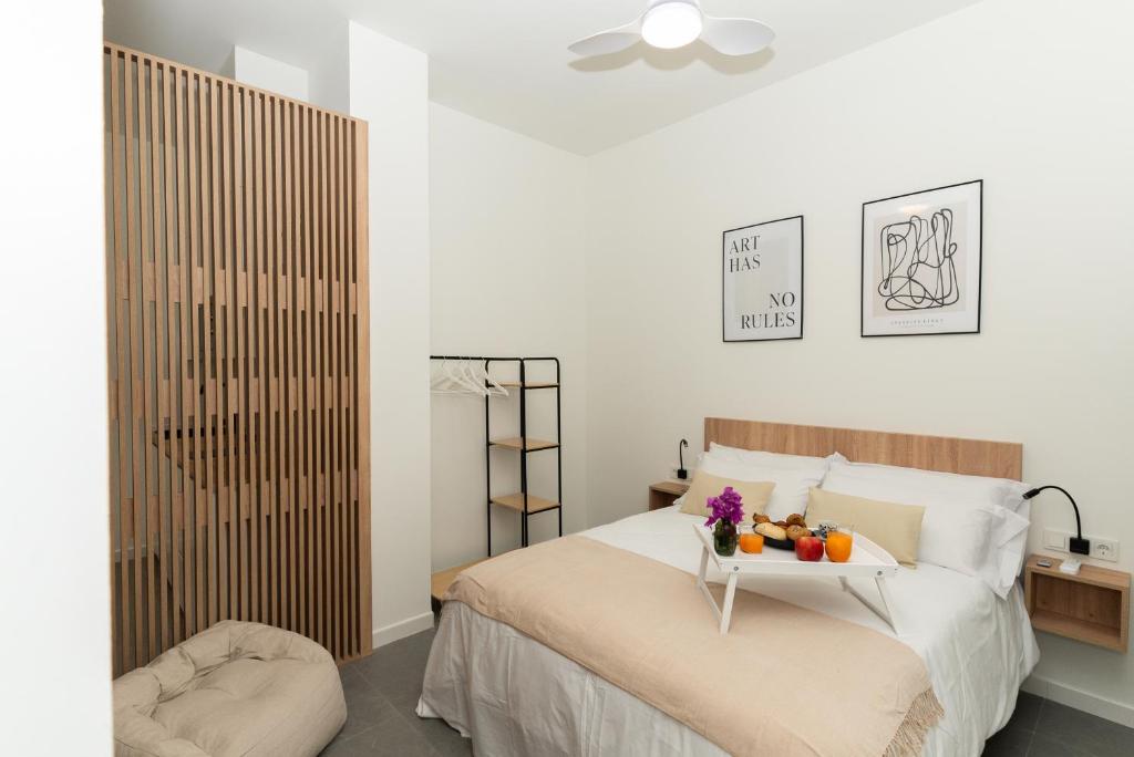 a bedroom with a bed with a tray of fruit on it at Lofts Jumaral - La Magdalena in Córdoba