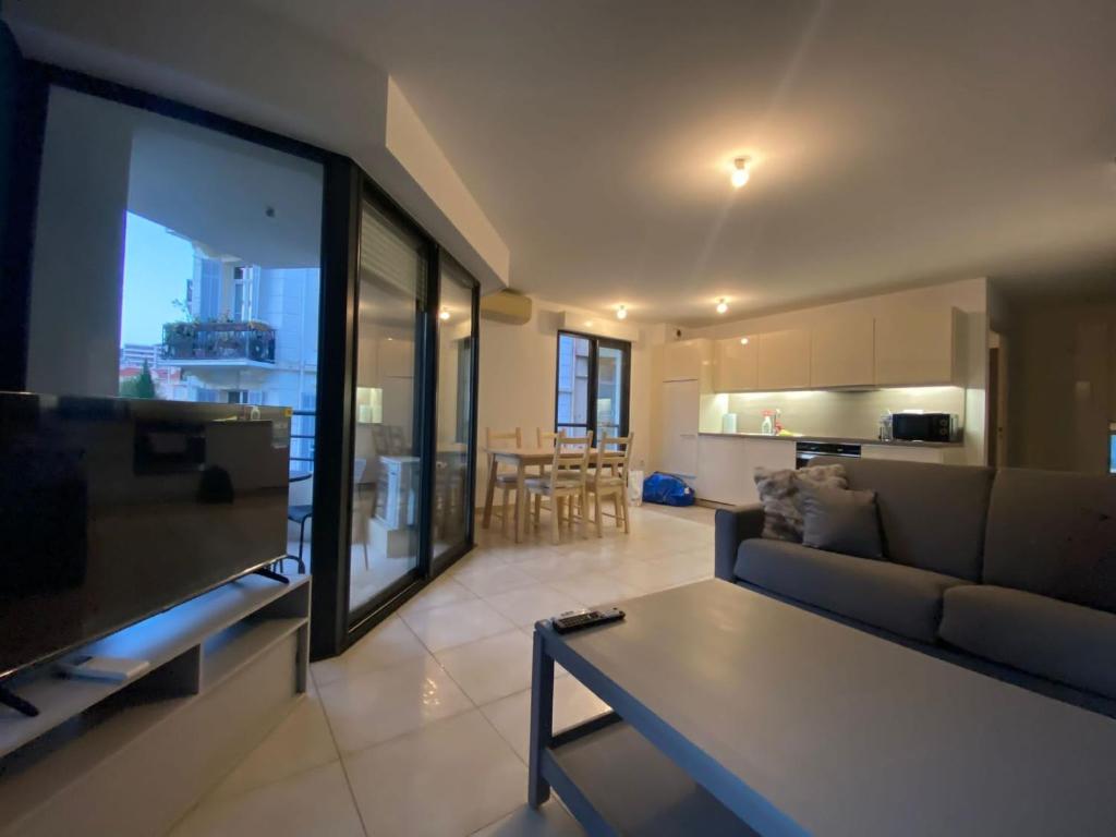 een woonkamer met een bank en een tv en een keuken bij Ref NASTIA - Palmes d'Or Properties in Cannes
