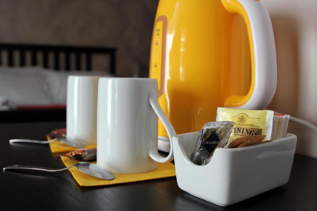 a table with two cups and a tea kettle at MilanoRooms Bacone Self Check-in in Milan