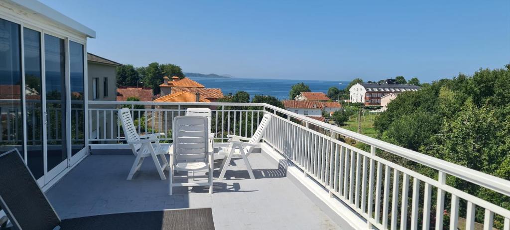 Un balcón con sillas y vistas al océano. en Apartamento en Nanin-Sanxenxo, en Sanxenxo