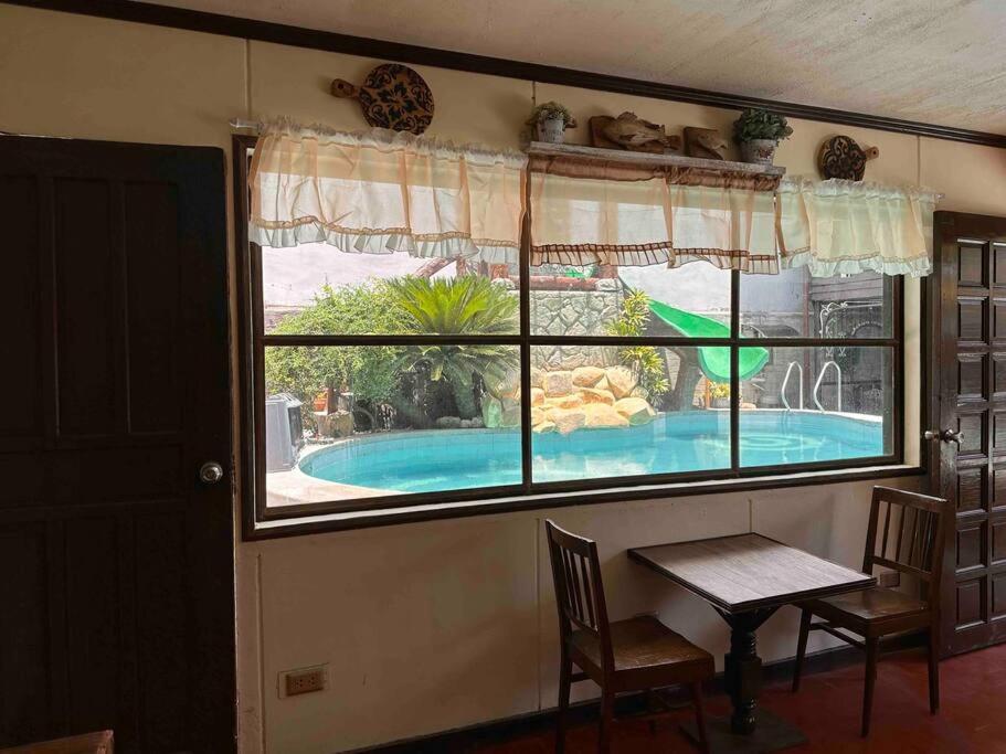 a view of a swimming pool through a window at Hotspring Resort with Videoke in Calamba