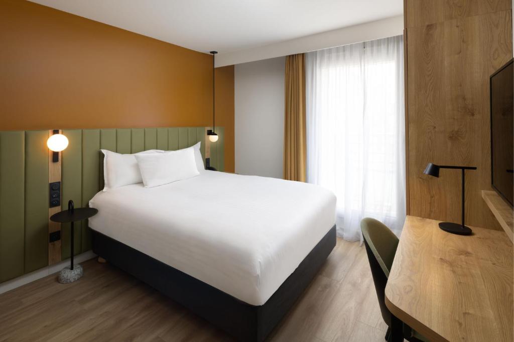 a bedroom with a large white bed and a table at Residence Inn by Marriott Paris Didot Montparnasse in Paris