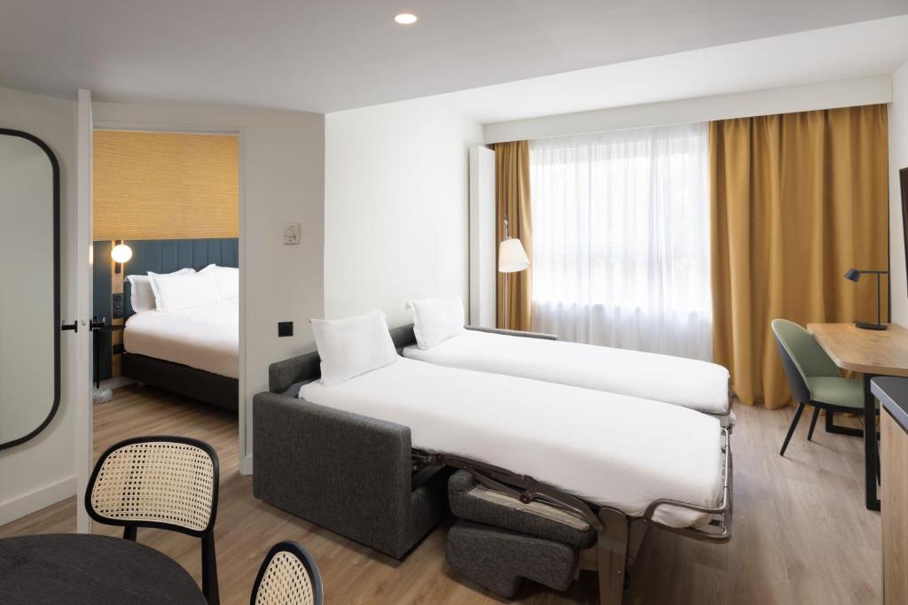 a hotel room with a large bed and a desk at Residence Inn by Marriott Paris Didot Montparnasse in Paris