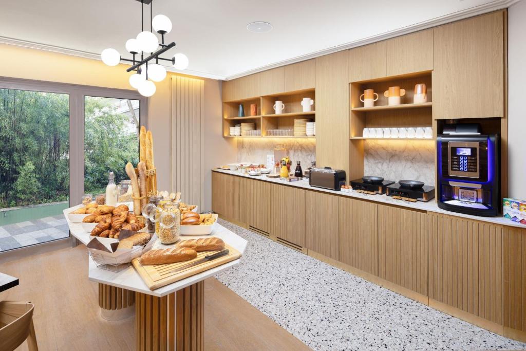 a breakfast room with a counter with bread and aasteryasteryasteryasteryasteryastery at Residence Inn by Marriott Paris Didot Montparnasse in Paris