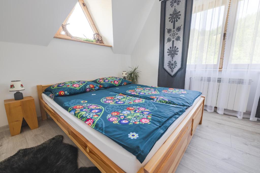 a bedroom with a bed with a blue comforter at Pokoje na Równi Zakopane in Zakopane