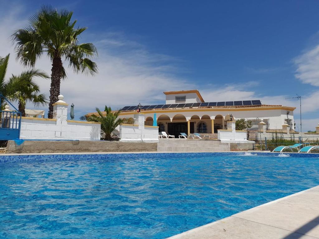 une grande piscine en face d'une maison dans l'établissement Chalet Bella Vista, à Lora del Río