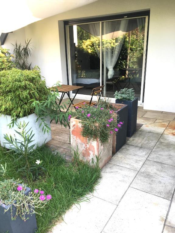 a patio with a table and some plants and flowers at COSY ROOM PRIVATE BATH AND GARDEN in Anglet