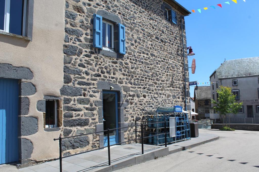 un bâtiment en pierre avec une porte sur son côté dans l'établissement Auberge de la Planèze, à Talizat