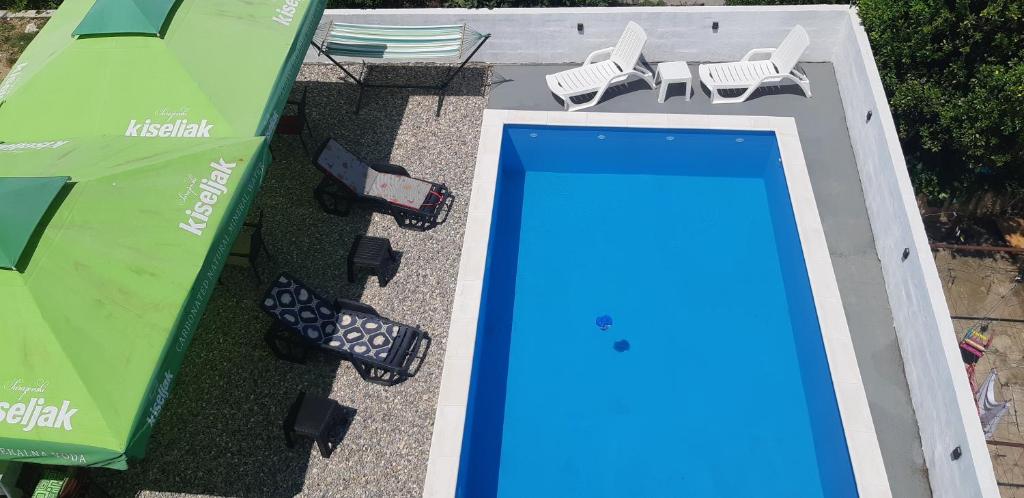 - une vue sur la piscine bordée de chaises et de parasols dans l'établissement Villa Hills, à Mostar