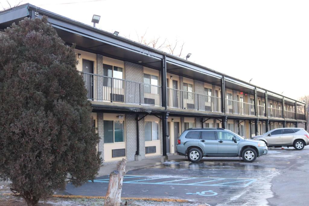 a car parked in a parking lot in front of a building at Travelodge by Wyndham Livonia Canton Novi Detroit Area in Livonia