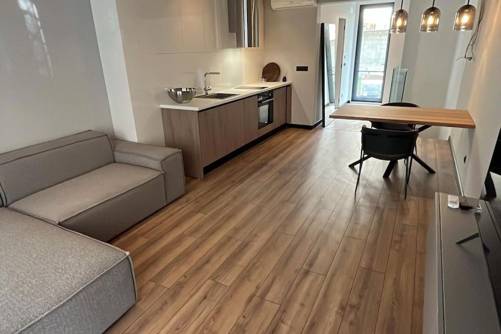 Una sala de estar con un sofá y una mesa y una cocina. en Amber Home - brand NEW luxury 1 bedroom apartment located in the very city center, en Varna
