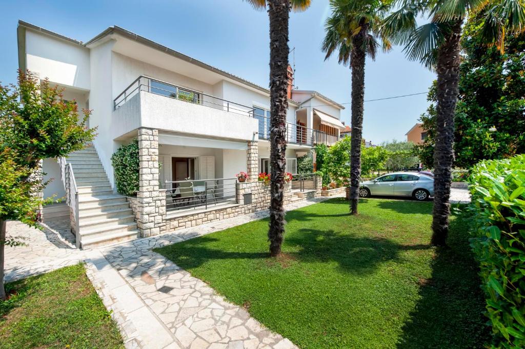 une maison avec des palmiers devant elle dans l'établissement Apartments Magnolia, à Rovinj