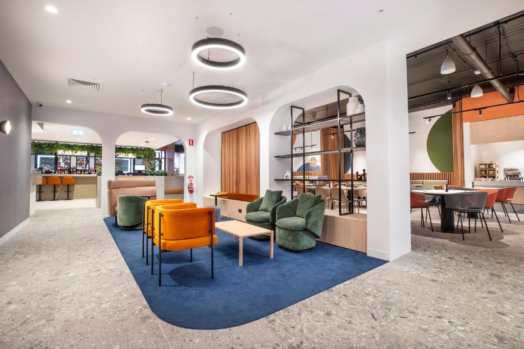 a lobby with chairs and a table in a building at Holiday Inn Dandenong, an IHG Hotel in Dandenong