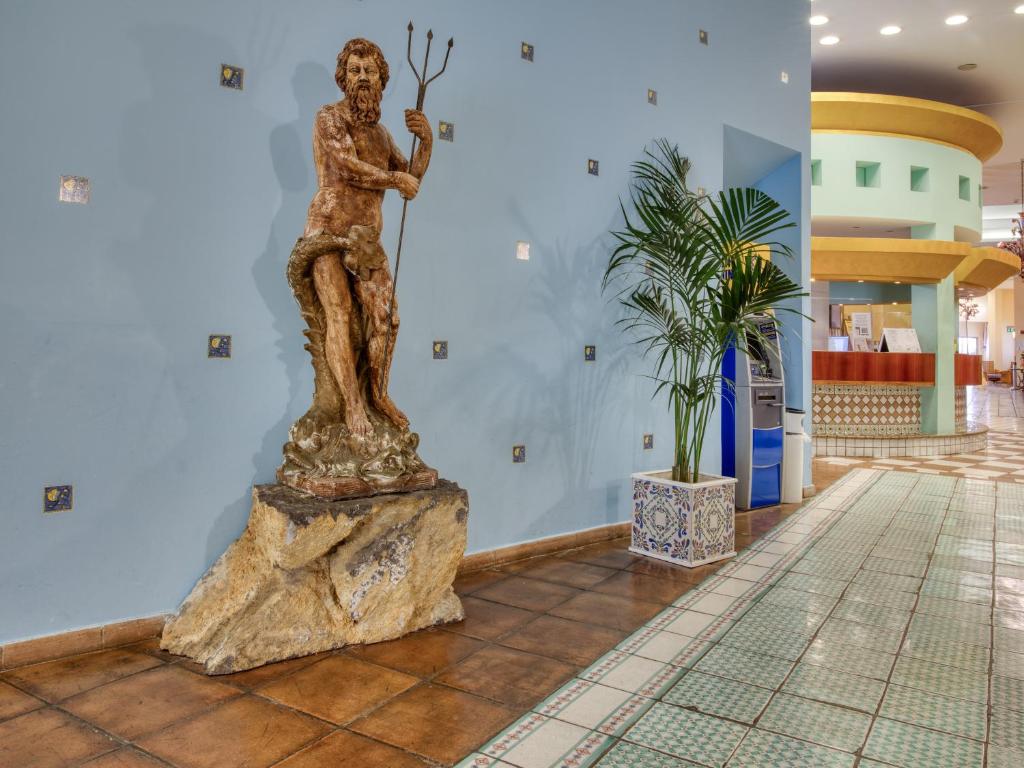 a statue of a man on a rock in a lobby at Hotel Olimpo le Terrazze in Letojanni
