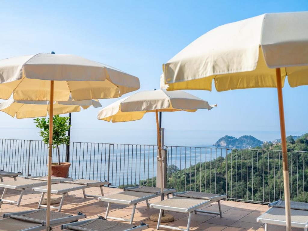 a row of chairs and umbrellas on a patio at Hotel Olimpo le Terrazze in Letojanni