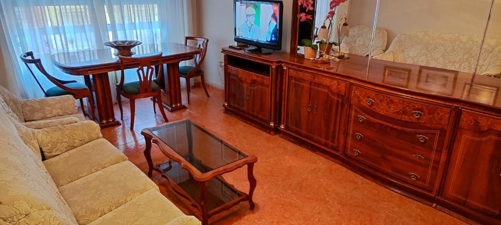 een woonkamer met een tv en een tafel en een bank bij Piso céntrico cerca de la feria y la catedral in Albacete