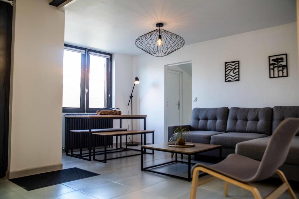 a living room with a couch and a table at Renovated T6 house with garden near transport in Villenave-dʼOrnon
