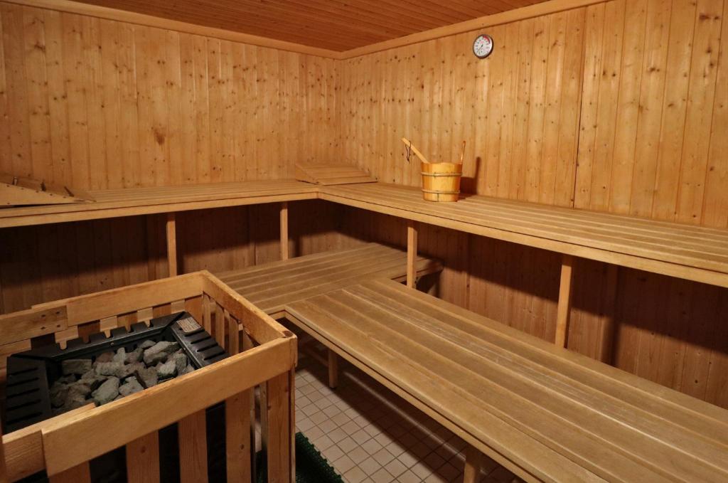 una sauna de madera con bancos y rocas. en Fewo 12 - Residenz Schauinsland, E-Ladestation, Todtnauberg, Feldberg, en Todtnauberg