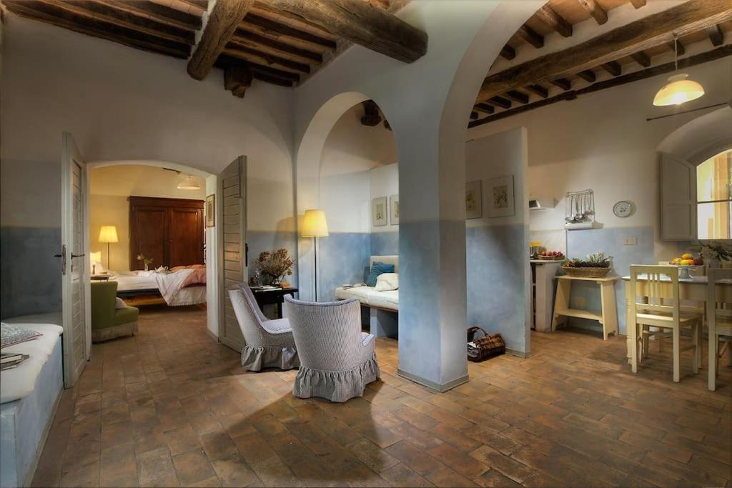 uma grande sala com uma sala de estar e uma sala de jantar em allegretti agriturismo em Castelnuovo Berardenga