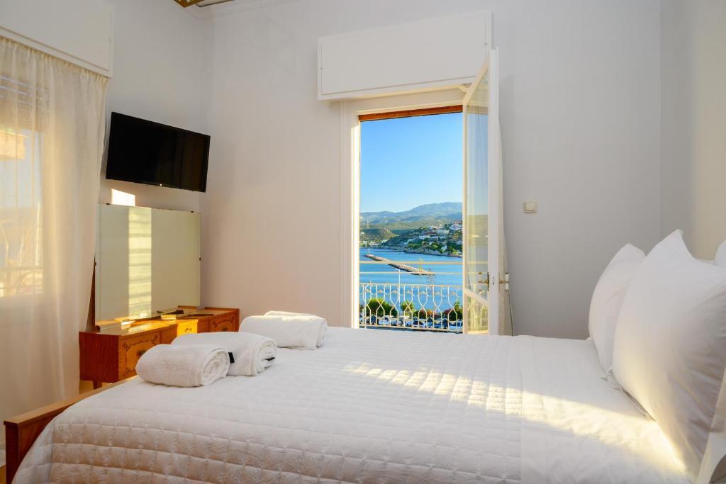 een slaapkamer met een groot wit bed met een raam bij R & G Seaview Apartment in Agios Nikolaos
