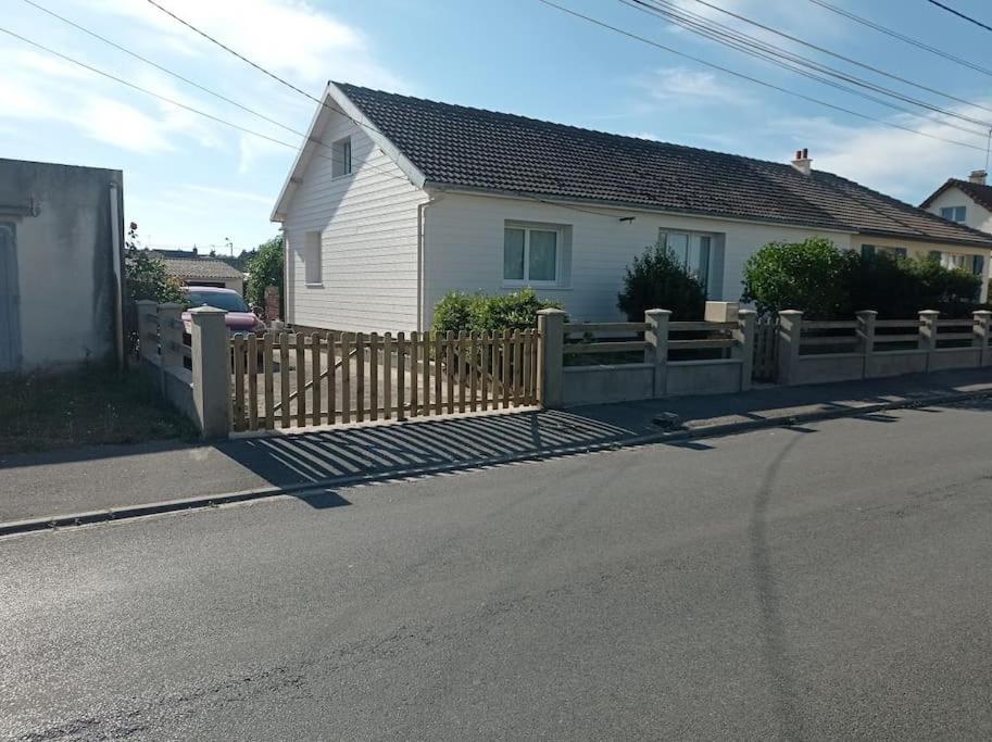 een houten hek voor een huis bij Maison tout confort avec jardin in Cayeux-sur-Mer