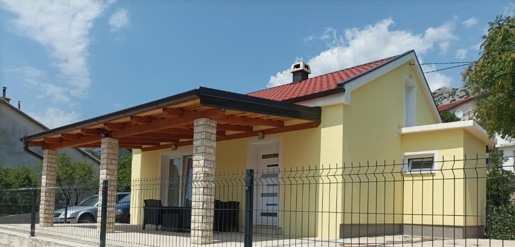 a small yellow house with a red roof at Holiday House Rose in Karlobag